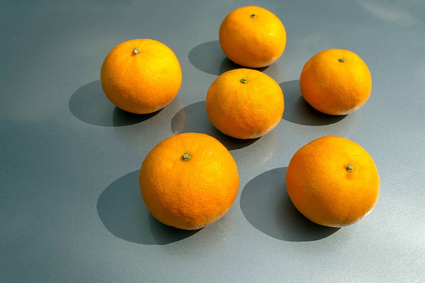 Lots of ripe juicy tangerines on a gray background - Fotoğraf, Görsel