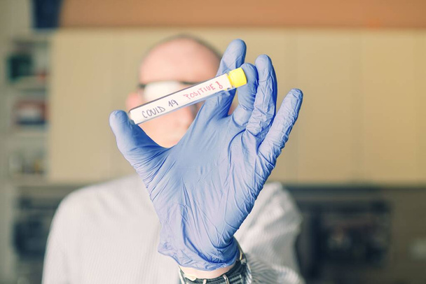 Le médecin tient dans sa main le vaccin contre le coronavirus COVID 19, échantillon infecté dans le tube d'échantillonnage, vaccin et injection de seringue. Il l'utilise pour la prévention, la vaccination et le traitement de la COVID-19.
. - Photo, image