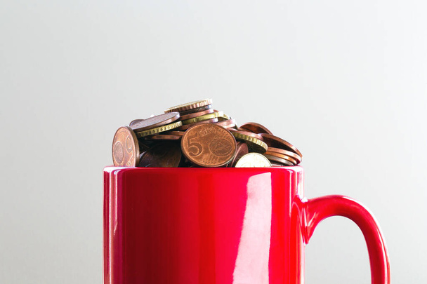 Avro sikkeleri ve iş konseptiyle dolup taşan Finans Hedeflerine Renkli bir kırmızı kupada Para Kurtarmak - Fotoğraf, Görsel