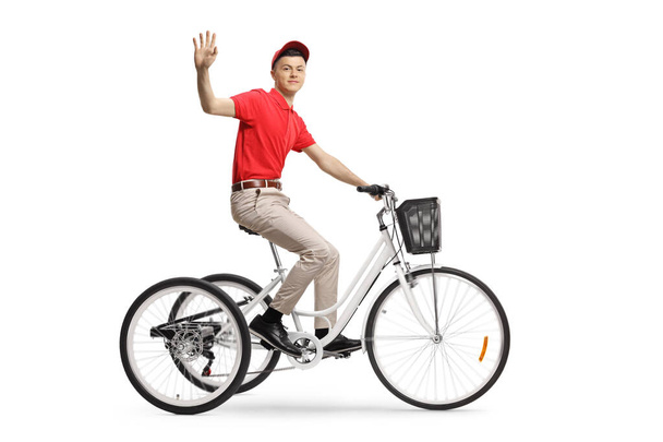 Pełne ujęcie dostawcy jeżdżącego na rowerze trzykołowym i machającego do kamery odizolowanej na białym tle - Zdjęcie, obraz