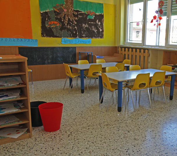 bancos y sillas de un jardín de infantes y muchos afiches
 - Foto, Imagen