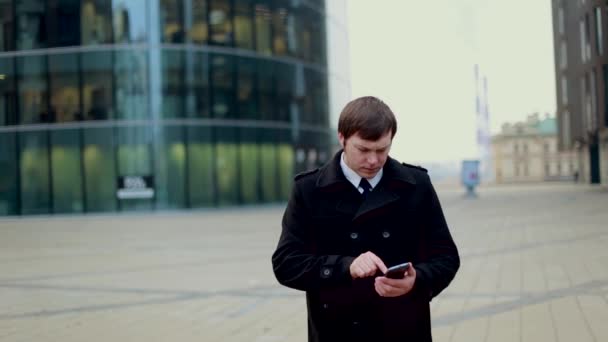 Businessman answering the phone dressed in a black coat - Кадри, відео