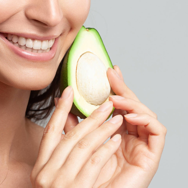 Young beautiful woman holding avocado.  Beauty, youth, skin care - Fotografie, Obrázek
