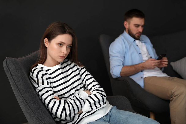 Man preferring smartphone over his girlfriend at home, focus on woman. Relationship problems - Photo, Image