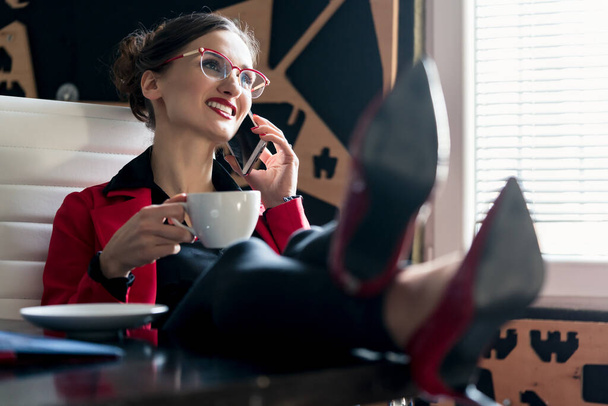 Bizneswoman pije kawę przez telefon - Zdjęcie, obraz
