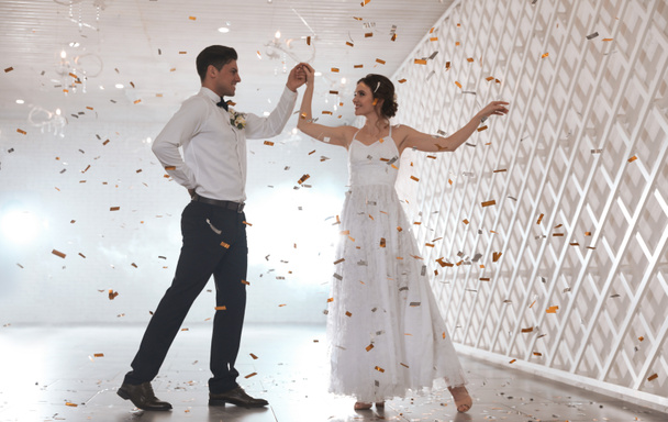 Happy newlywed couple dancing together in festive hall - Fotografie, Obrázek