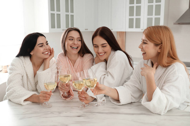 Beautiful young ladies with glasses of wine in kitchen. Women's Day - Foto, immagini