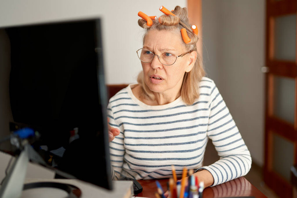 Συνταξιούχος μεσήλικας σε γυαλιά χρησιμοποιώντας ηλεκτρονικό ταχυδρομείο δακτυλογράφησης laptop που εργάζεται στο γραφείο στο σπίτι - Φωτογραφία, εικόνα