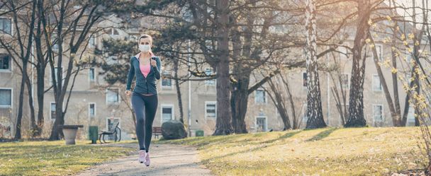 Woman jogging down a path boosting her immune system for covid-19 - 写真・画像