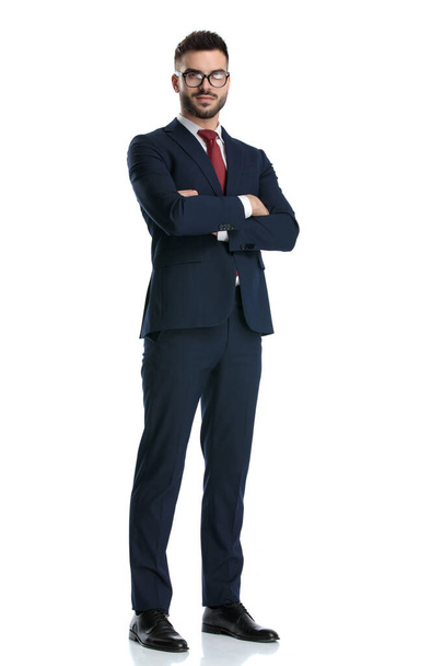 sexy hombre de negocios con gafas de pie con los brazos cruzados al pecho y posando feliz sobre fondo blanco estudio
 - Foto, imagen