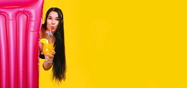 dziewczyna z koktajlem i materacem na żółtym tle, wakacyjny pomysł, makieta panoramiczna - Zdjęcie, obraz