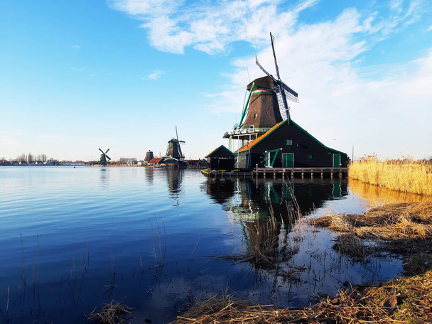 вітряк у ротердамі на спокійному озері, де він відображає чисте небо та структуру будівлі в Холланді
 - Фото, зображення