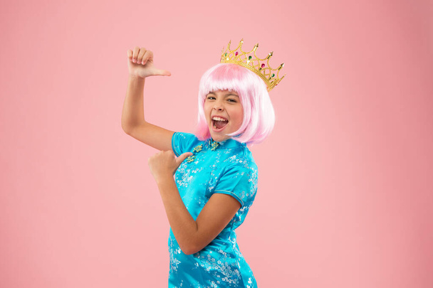 Happy girl crown pink background. Coronate symbol. coronavirus made in china. chinese child in kimono. princess point finger. her japan vacation. luxury looking queen. Little miss got reward - Φωτογραφία, εικόνα