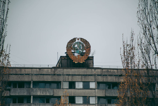 Old Soviet building with the coat of arms in Pripyat in Chernobyl - Fotó, kép