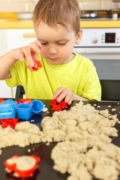 Cute little boy age of 3 years plays kinetic sand at home - Photo, Image