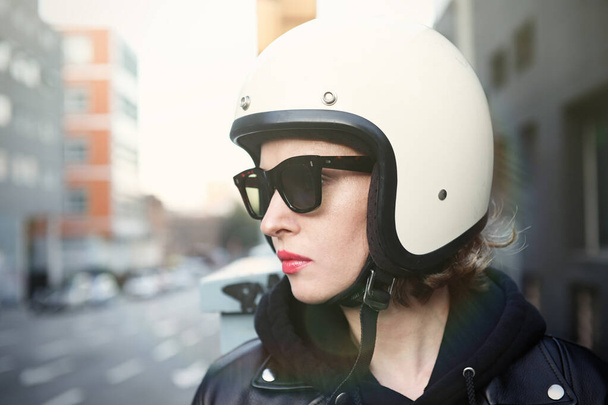 Close-up portrait of biker girl wearing sunglasses and white helmet. Outside image. - Fotó, kép