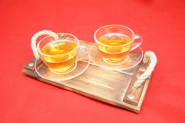 Duas xícaras de chá verde em um fundo vermelho
 - Foto, Imagem