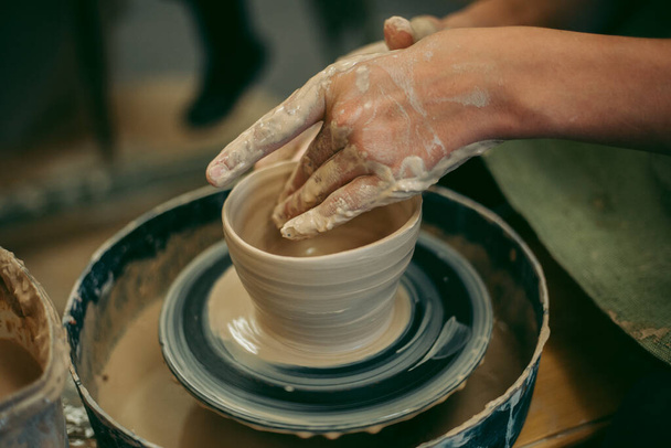 Potter creates a clay jug with his hands - Foto, afbeelding