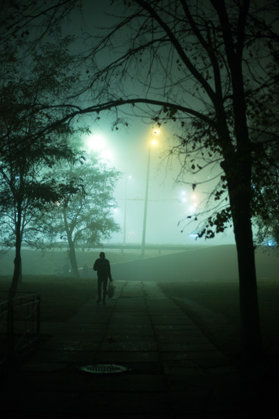 Одинокий человек ночью в тумане в городе
 - Фото, изображение