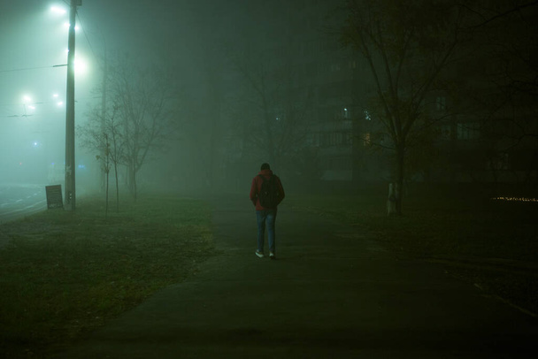 Lonely man at night in the fog in the city - Photo, Image
