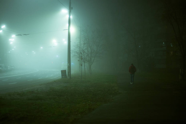 Eenzame man 's nachts in de mist in de stad - Foto, afbeelding