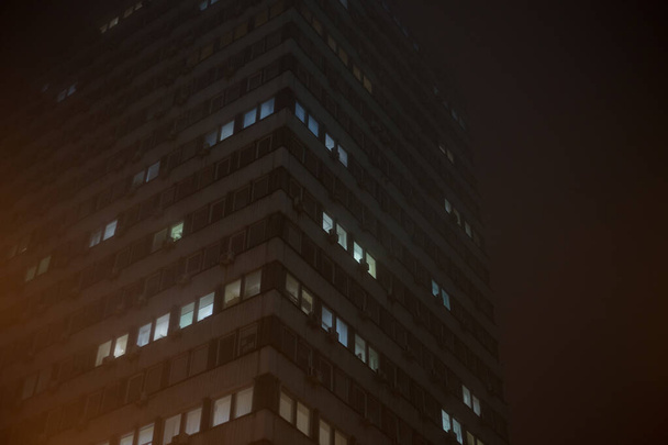 Groot kantoorgebouw 's nachts in mistig - Foto, afbeelding