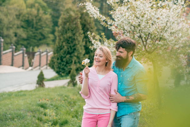 Couple in live walking in the spring Park and enjoying the beautiful spring blossom nature. - Photo, Image