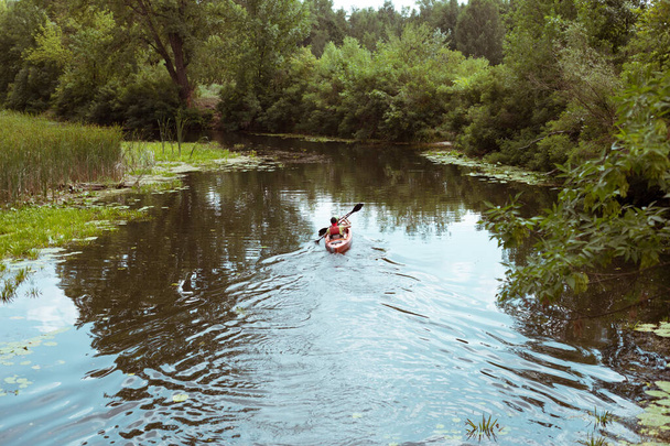 Un chico y una chica en canoa remando por el río
 - Foto, imagen