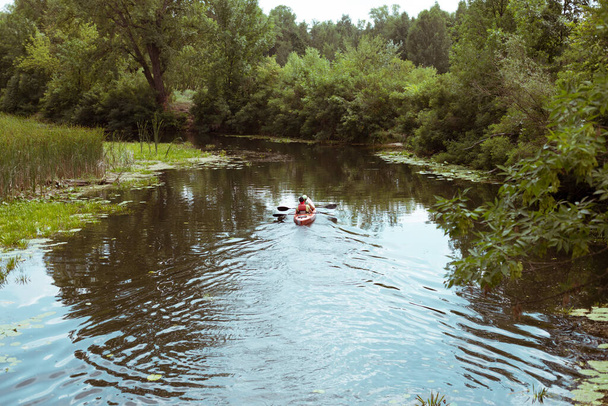 Egy fiú és egy lány kenu eveznek a folyón. - Fotó, kép