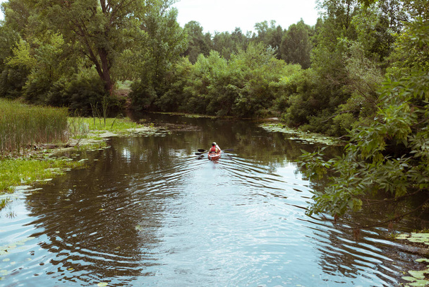 Facet i dziewczyna pływają kajakiem po rzece - Zdjęcie, obraz