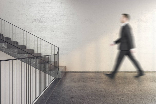 Businessman walking on stairs in office building with copy space on wall. Performance and presentation concept. - Foto, afbeelding