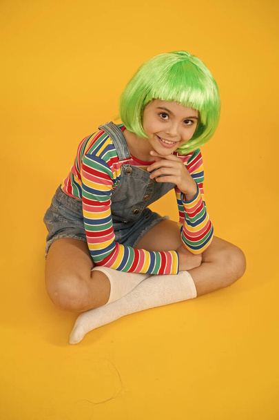 Create new look in salon. Happy girl with beauty look. Little child wear green hair wig in fancy style. Beauty and hair salon. Fashion salon. Salon or parlor. Color and style hair using creativity - Foto, afbeelding