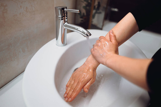 γυναίκα πλύσιμο των χεριών και σαπούνι καθαρισμού με καθαρό νερό  - Φωτογραφία, εικόνα