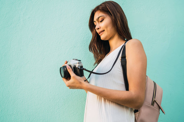 Retrato de una joven fotógrafa usando una cámara digital profesional. Concepto de fotografía
 - Foto, Imagen