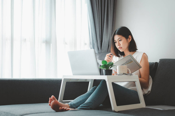Asian woman working with laptop notebook at home on sofa  - Photo, image