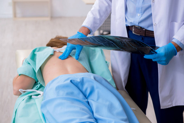 Giovane donna ferita alla schiena in visita medico chiropratico maschile
 - Foto, immagini