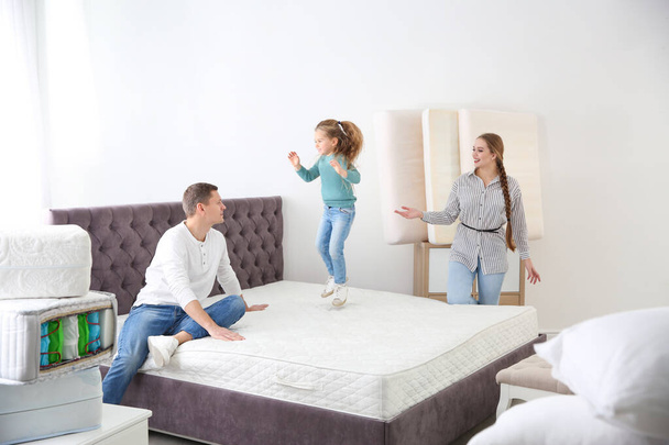 Happy family choosing mattress in furniture store - Foto, immagini