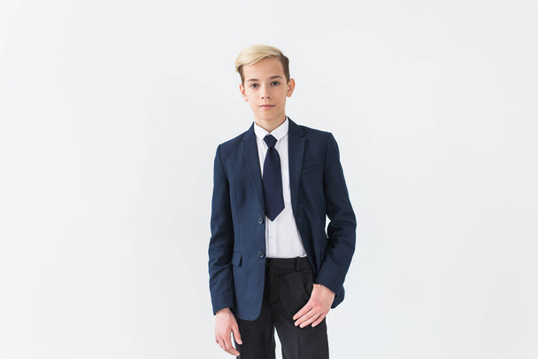 Portrait of stylish school boy teenager in white shirt and jacket against white background with copy space. - Photo, Image