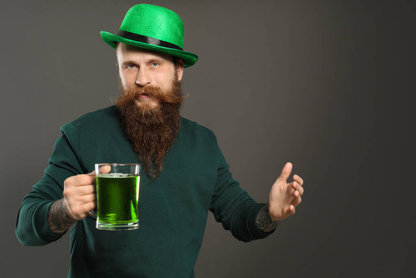 Man with green beer on grey background. St. Patrick's Day celebration - Φωτογραφία, εικόνα