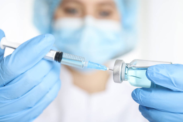 Doctor filling syringe with medication, closeup. Vaccination and immunization - Фото, изображение