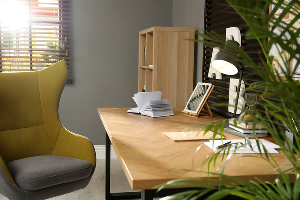 Comfortable workplace with wooden table and armchair - Zdjęcie, obraz
