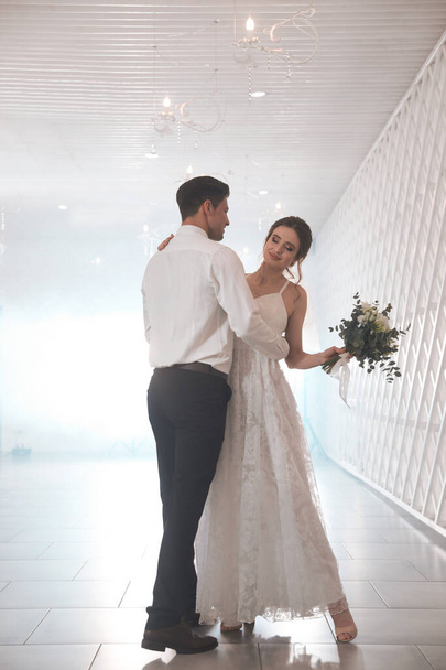 Šťastný novomanželský pár tančí společně ve slavnostním sále - Fotografie, Obrázek
