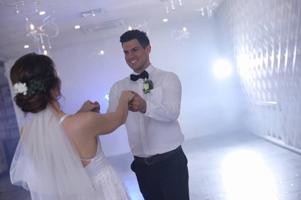 お祝いのホールで一緒に踊る幸せな新婚カップル - 写真・画像