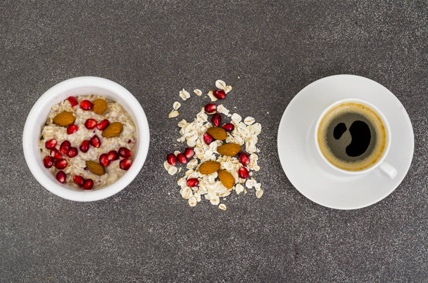 Gesunde Ernährung, Frühstück. Haferflocken mit Granatapfel und Nüssen, schwarzer Kaffee. Studioaufnahme - Foto, Bild