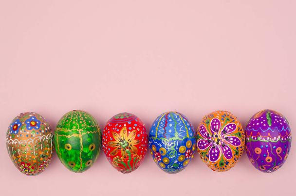Belos ovos de Páscoa pintados à mão em um fundo rosa claro
 - Foto, Imagem