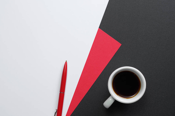 Sábanas de papel blanco y rojo con un bolígrafo y una taza de café sobre una mesa negra, vista superior
 - Foto, imagen