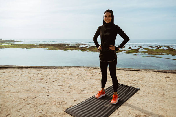 muslim sport woman on the beach exercising - Fotó, kép
