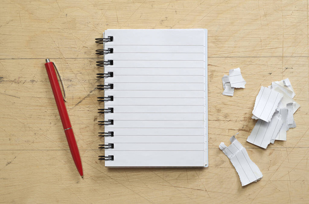 Nyílt notebook, piros toll és szakadt papír régi fa háttér, felülnézet - Fotó, kép