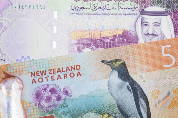 Egy színes ötdolláros bankjegy Új-Zélandról, makróban, egy öt szaúdi riyal bankjeggyel Szaúd-Arábiából. - Fotó, kép