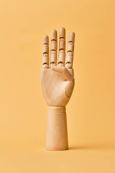 Wooden human hand with four fingers raised up - Fotografie, Obrázek